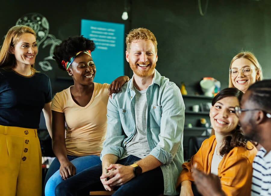 Importancia de la inteligencia espiritual tips - Grupo de trabajo diverso compartiendo y sonriendo en un ambiente informal.
