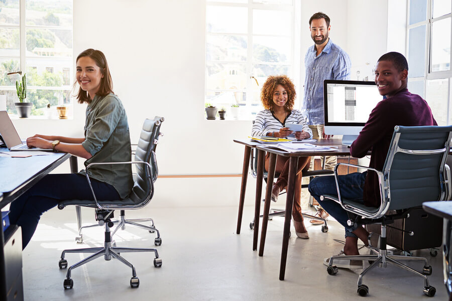 Tecnología y talento humano efectos - Equipo de trabajo en oficina moderna colaborando y sonriendo.
