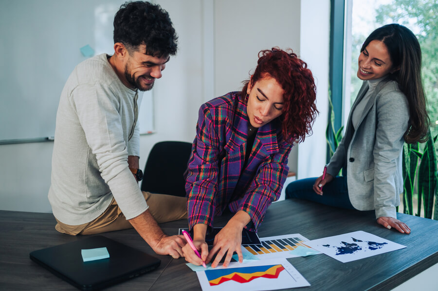 Estrategias para atraer talento humano estrategias - Personas revisando y analizando gráficos de crecimiento en una reunión de trabajo.
