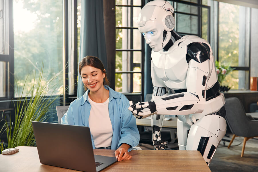 Mujer trabajando en laptop con un robot humanoide asistiendo a su lado