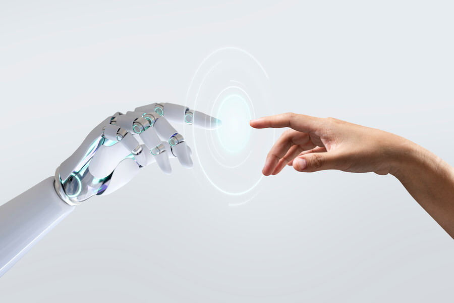 Inteligencia artificial en talento humano - Mano humana y mano robótica acercándose con un punto de conexión