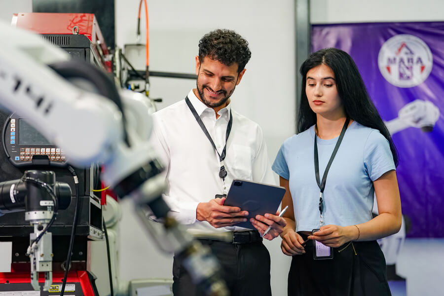 Beneficios de la inteligencia artificial para las empresas prediccion - Ingenieros supervisando un brazo robótico en un entorno industrial.