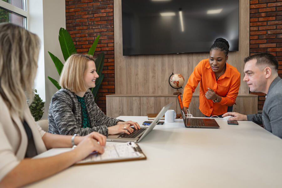 Payrolling que es definición - Reunión de trabajo con presentación frente a laptop en oficina moderna.
