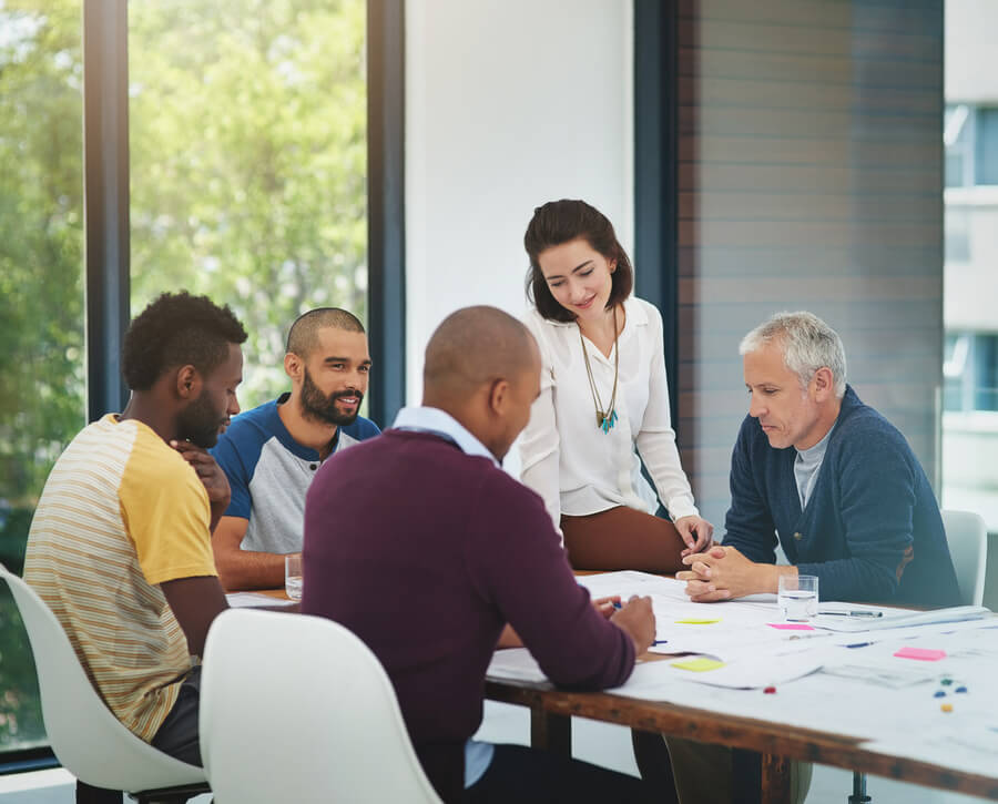 10 pasos para un proceso de selección efectivo importancia - Personas en una reunión de trabajo colaborando alrededor de una mesa.