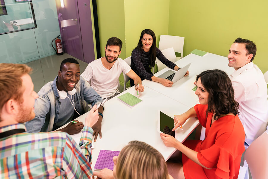 Como liquidar una nómina emite el recibo - Grupo diverso de personas en reunión creativa alrededor de una mesa.