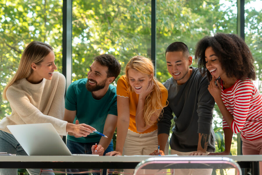 Gestión de nómina principal - Grupo de jóvenes colaborando en proyecto frente a una laptop.