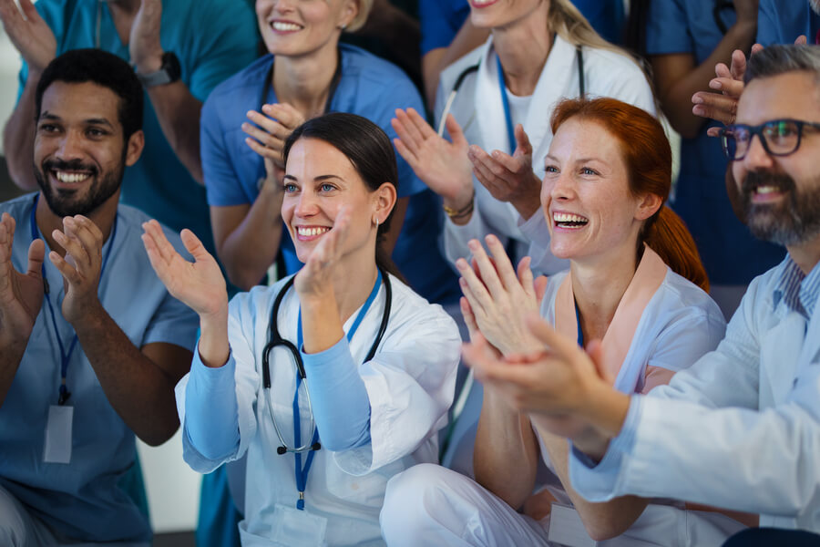 Reforma laboral Colombia nocturna recargos - Grupo de profesionales de la salud aplaudiendo y sonriendo.