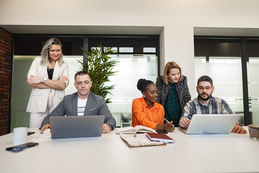 Reforma laboral Colombia principales cambios - Equipo de trabajo colaborando frente a computadoras en una oficina.
